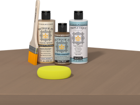 Retique It® Barn Wood Multipurpose Kit contents with Light Wood Liquid Wood primer, Barn Wood gel stain alternative, Tripletique matte interior top coat, paintbrush, and yellow sponge displayed on a wood surface.