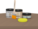 Retique It® Barn Wood Multipurpose Kit contents with Light Wood Liquid Wood primer, Barn Wood gel stain alternative, PolyTique It® matte exterior top coat, paintbrush, and yellow sponge displayed on a wood surface.