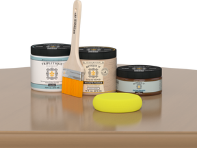 Retique It® Pecan Multipurpose Kit contents with Light Wood Liquid Wood primer, Pecan gel stain alternative, Tripletique gloss interior top coat, paintbrush, and yellow sponge displayed on a wood surface.