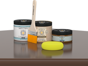 Retique It® Dark Oak Multipurpose Kit contents with Liquid Wood primer, Dark Oak gel stain alternative, Tripletique gloss interior top coat, paintbrush, and yellow sponge displayed on a dark wood surface.