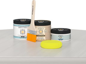 Retique It® White Wash Multipurpose Kit contents with Liquid Wood primer, White Wash gel stain alternative, Tripletique satin interior top coat, paintbrush, and yellow sponge displayed on a white wood surface.