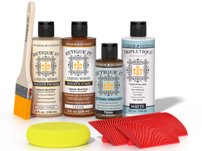 Retique It® Wood'n Finish Kit in Cedar stain with wood finishing tools and stain bottles on a workspace table.