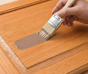 Retique It Universal Liquid Wood Kit in dark wood applying finish to cabinet surface for a natural wood look.