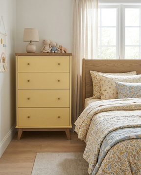 Yellow dresser next to a bed with floral bedding in a bedroom setting.
